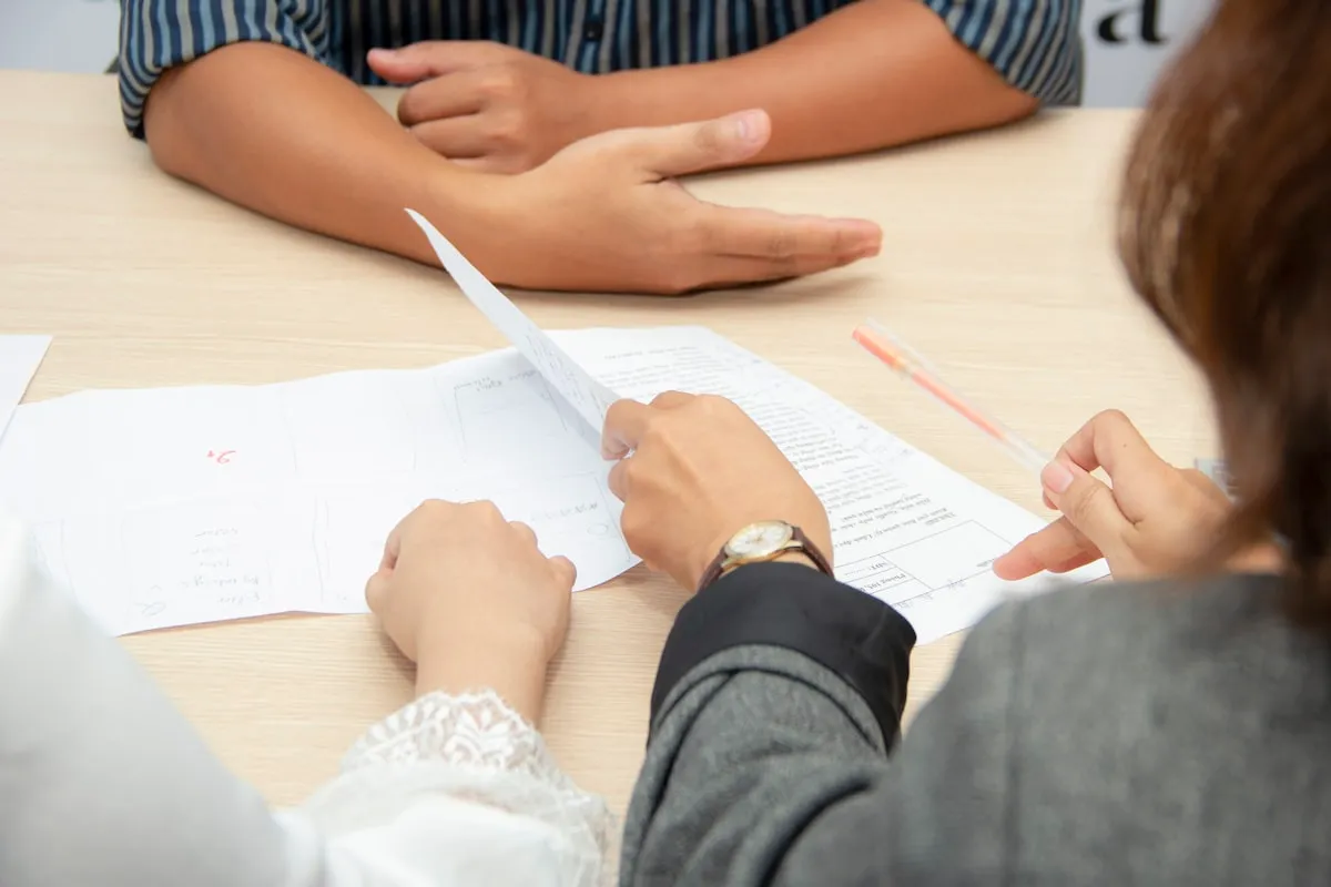 Two people reviewing paperwork together at a table