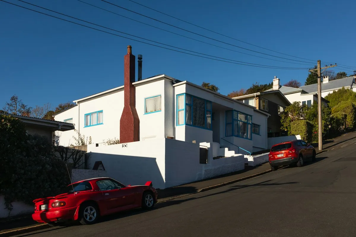 A New Zealand suburban street of weatherboard houses in late afternoon light